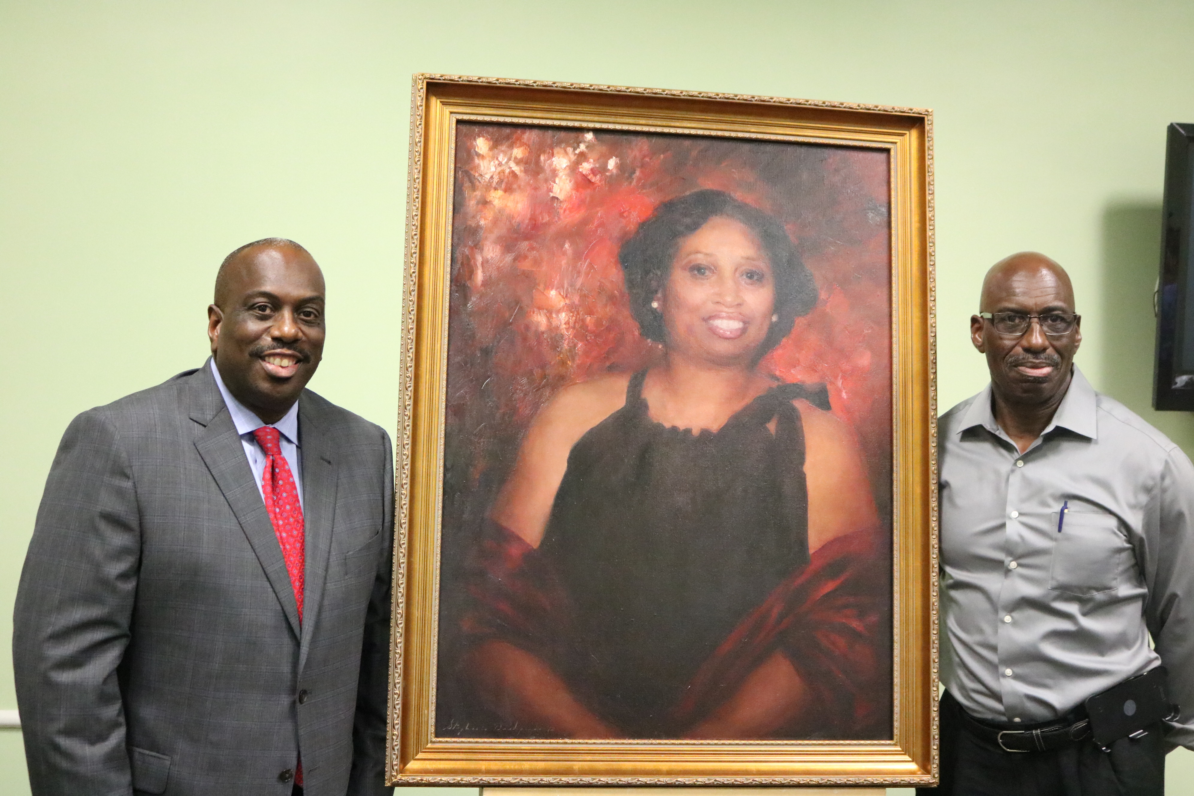 Malcolm and Melvin Graham pose next to the portrait of their sister, Cynthia. 